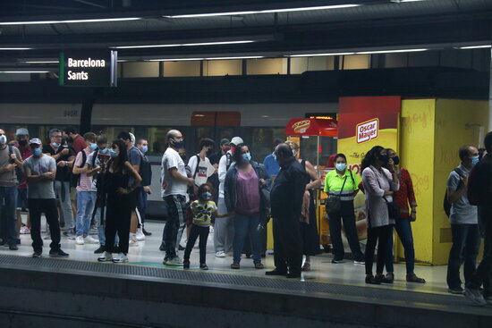 Some commuters waiting for their train in Barcelona's Sants station on September 30, 2021 (by Albert Cadanet)